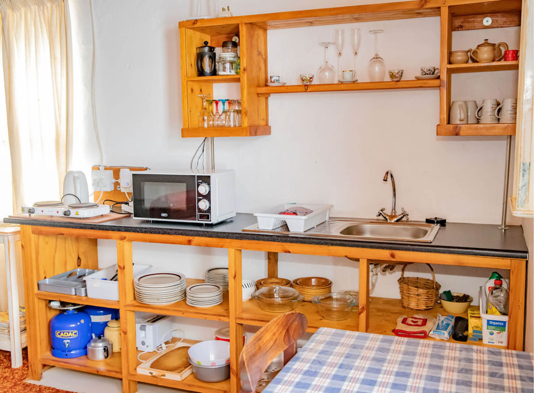 Oupad Se Kloof kitchenette with open shelves, gas and microwave